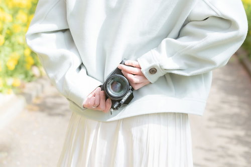 春の光の中で後ろ向きにカメラを持つ女性のポートレート