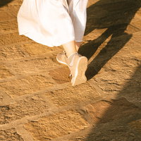 夕日に照らされた女性の歩くスニーカーの裏の写真