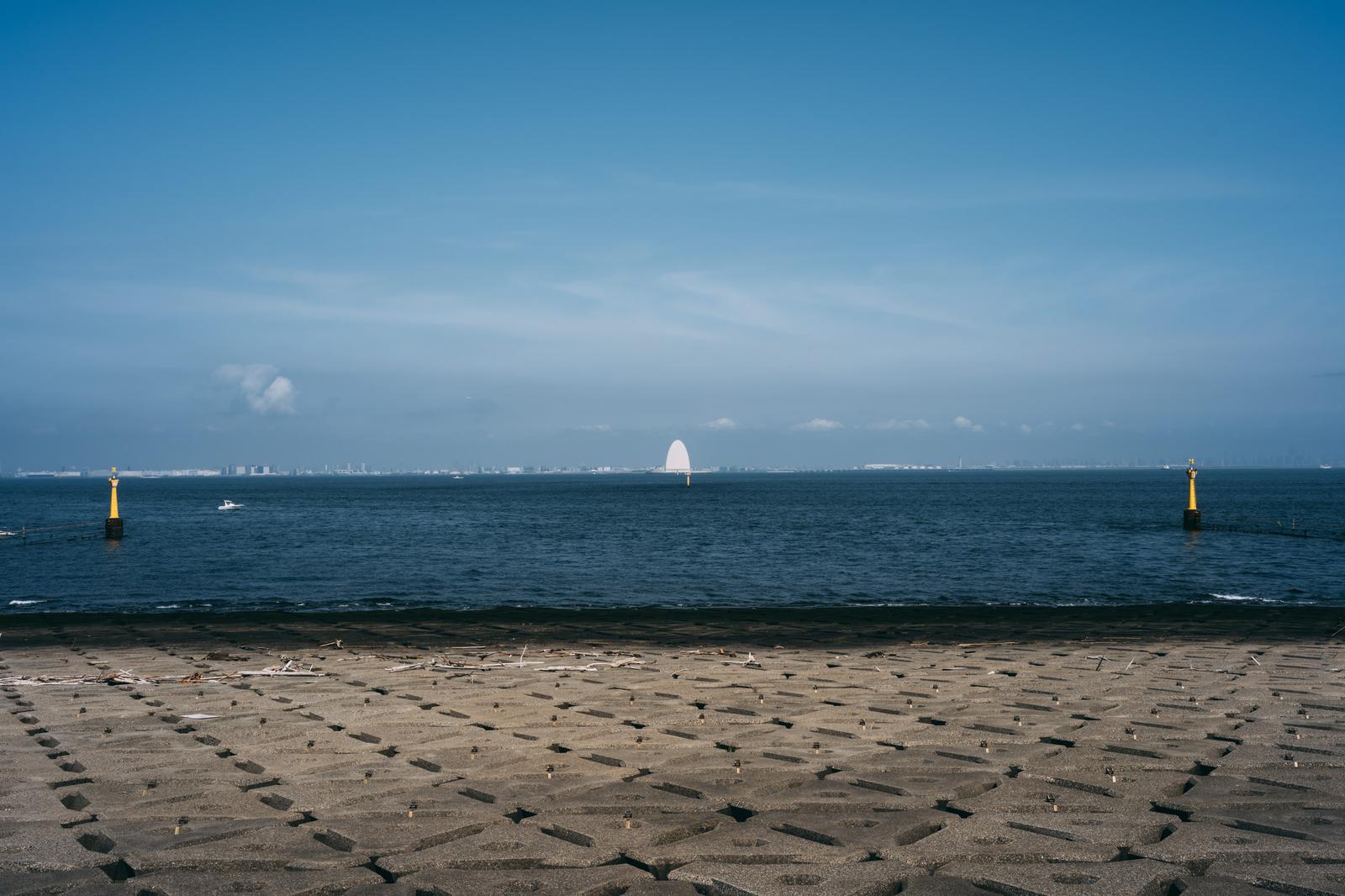 東京湾に浮かぶ白い帆の船と黄色いブイが見える海ほたることからの景観