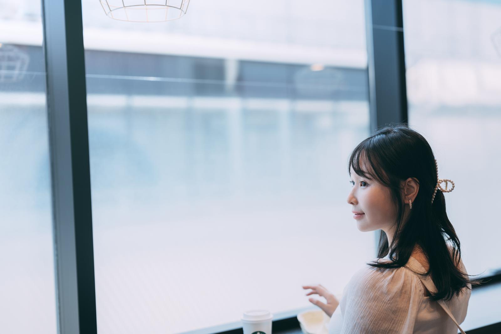 海ほたるの休憩所で窓辺に立ち外を眺める女性［モデル：茜さや］