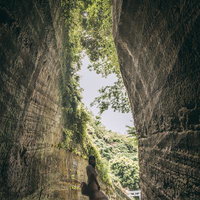 燈籠坂大師の切通しトンネルで背伸びする女性の写真