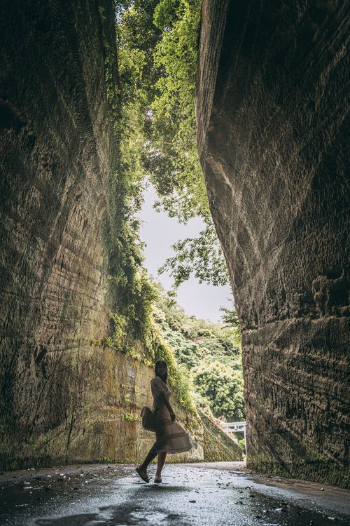 燈籠坂大師の切通しトンネルで背伸びする女性