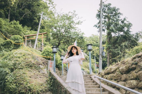 燈籠坂大師の石段を下りる麦わら帽子の女性