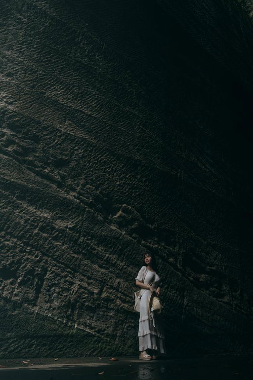 燈籠坂大師の薄暗い切通しトンネルで涼風を感じる女性