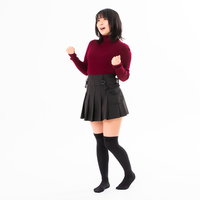 赤紫のセーター姿で両手の拳を握り歓喜する女性の写真