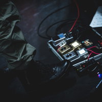 ライブステージの足元に置かれた複数のエフェクターの写真