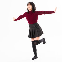 目を閉じてバランス感覚を養うヤジロベーポーズの女性の写真
