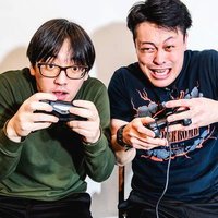 コントローラーを握ってゲームに熱中する二人の男性の写真