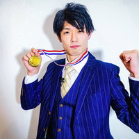 金メダルを獲得してカメラにガッツポーズする男性の写真