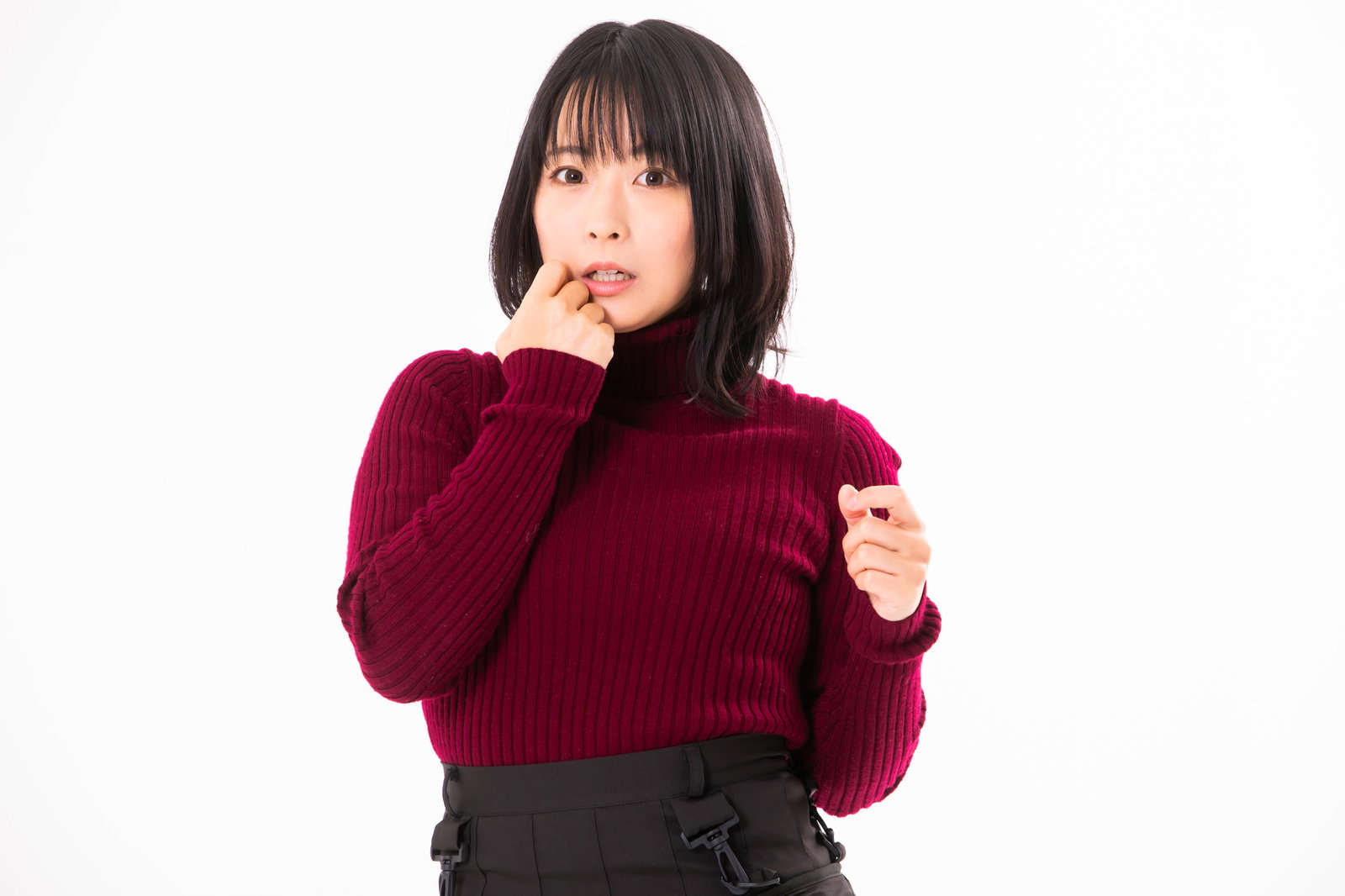 赤いセーターを着た女性が驚いた表情で両手を前に出している［モデル：にゃるる］