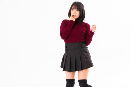 顎に手をあてて動揺する女性のポーズ、赤いセーター姿