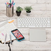 デスクの上に置かれた白いキーボードやタッチパッドとガジェットの写真