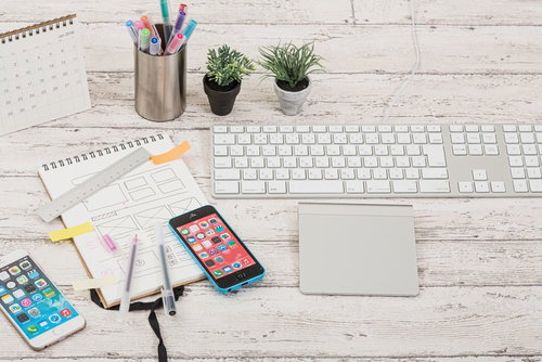 デスクの上に置かれた白いキーボードやタッチパッドとガジェット