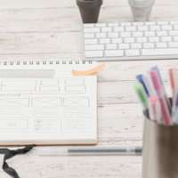 デスクに広げた色付き付箋が張られたメモ用紙の写真