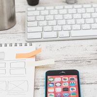 メモ用紙に貼られたオレンジ色の付箋紙とスマートフォンの写真