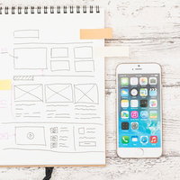 Webサイトのデザイン打ち合わせに使うスマホとノートの写真