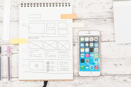 Webサイトのデザイン打ち合わせに使うスマホとノート