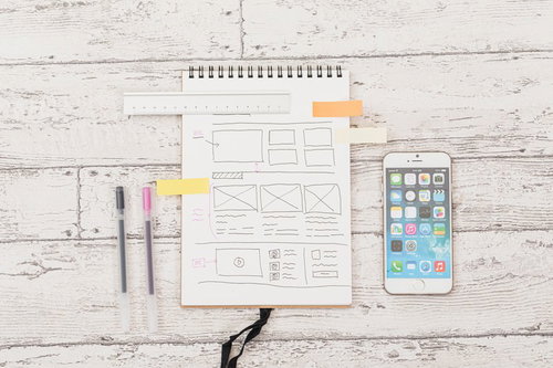 iPhoneと一緒に置かれた文具とノート