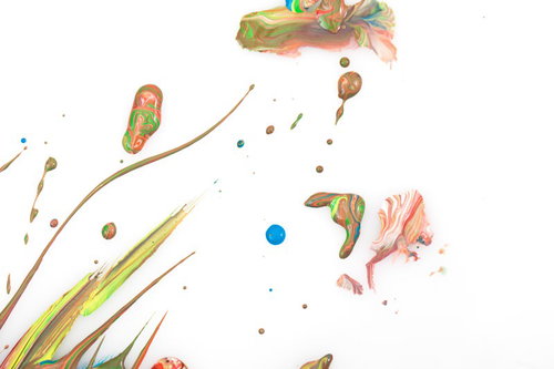 白い背景に飛び散ったペンキと画材、筆やパレットナイフ