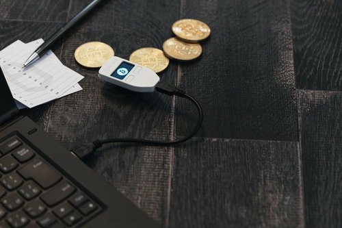 資産管理中のビットコインウォレットTREZORと金色のビットコインコイン