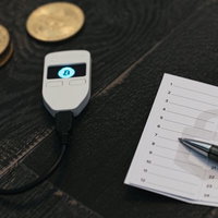 ハードウェアウォレット（TREZOR）とパスワード用のメモ書きの写真