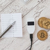 メモ書きと並べたTREZORとビットコインの写真
