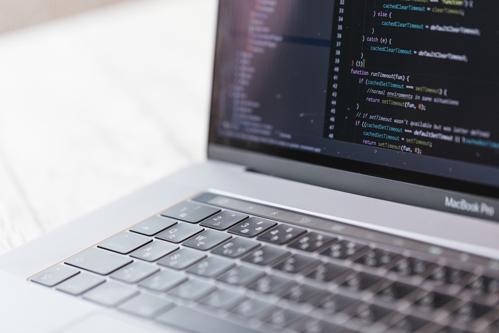 MacBook Proの液晶画面にプログラミングのソースコードが表示されている様子