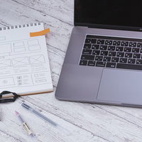 付箋でチェックされたメモ用紙とMacbook Proの写真