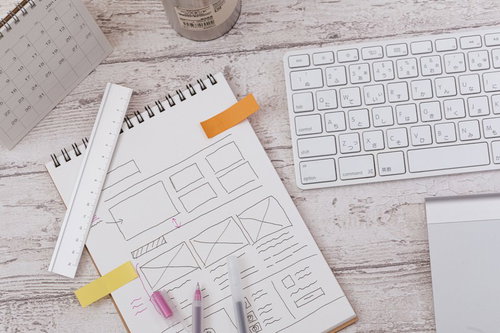 スクワーク中のノートとキーボード、文具が並べられたデスク