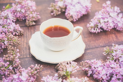 白いティーカップから広がるライラックの花