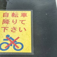 自転車を降りてください、歩道に設置された注意喚起看板の写真