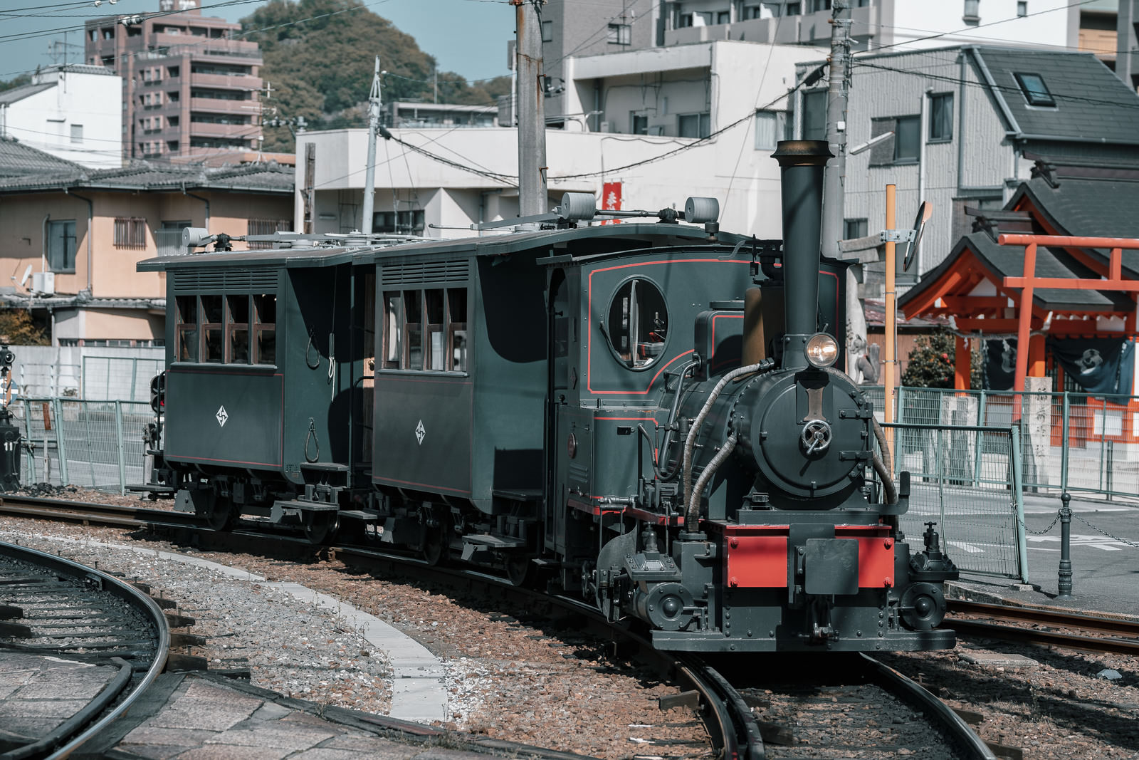 愛媛県松山市の伊予鉄道で運行される濃緑色の蒸気機関車・坊っちゃん列車が線路に停車している
