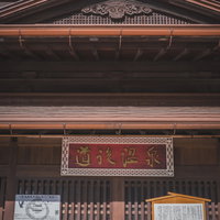 道後温泉の老舗店頭に掲げられた赤い看板と格子戸の写真