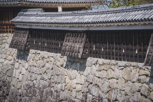 松山城の石垣上に構える重厚な土塀と狭間、瓦葺き屋根