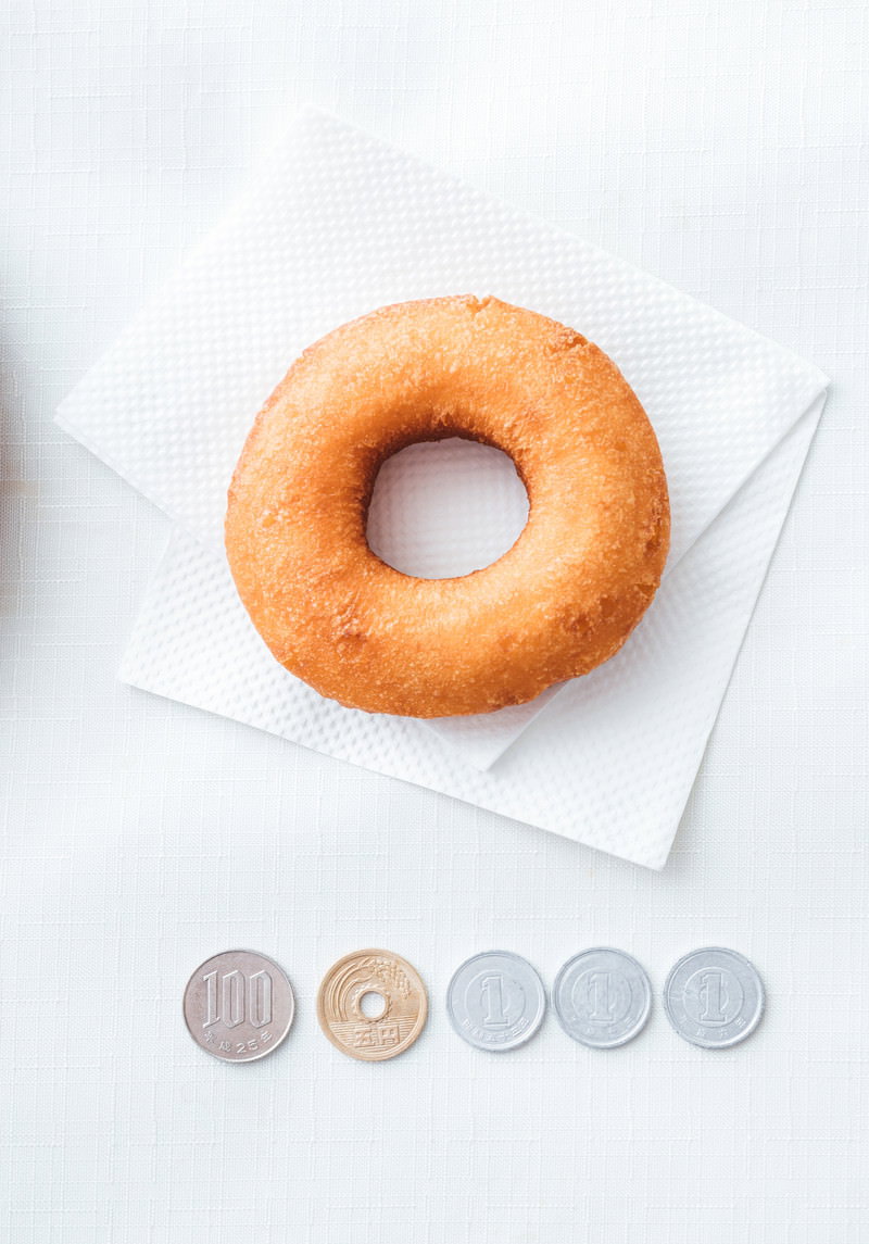 白い紙の上に置かれたオレンジ色のドーナッツと税率アイコン