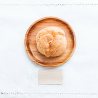 木製の皿に盛られたおやつのシュークリームの写真