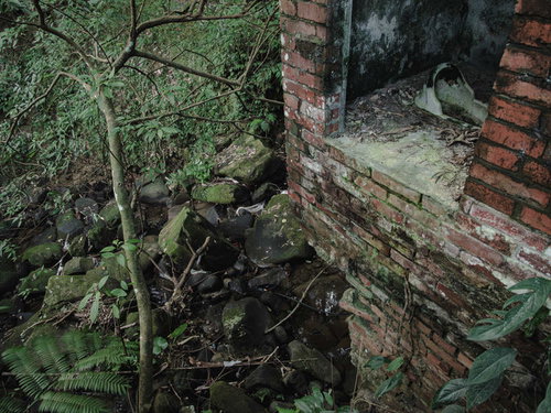 廃墟と化した炭鉱住宅の半壊した煉瓦の壁と便器