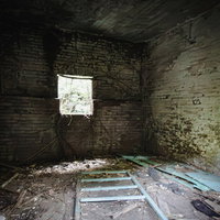 ボロボロに崩れ落ちた廃屋の窓から差し込む光の写真