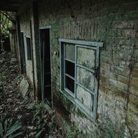 廃墟のレンガ外壁に残る窓枠とボロボロになった壁面の写真