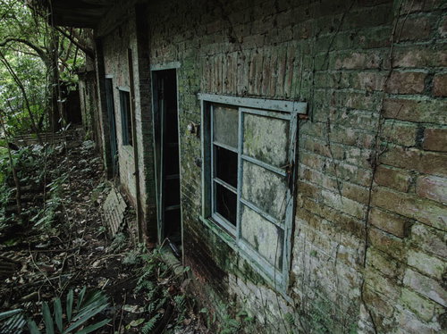 廃墟のレンガ外壁に残る窓枠とボロボロになった壁面