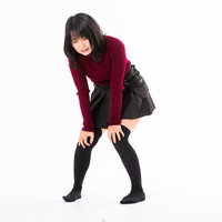 全力で走り過ぎて膝が笑う女性のポーズの写真