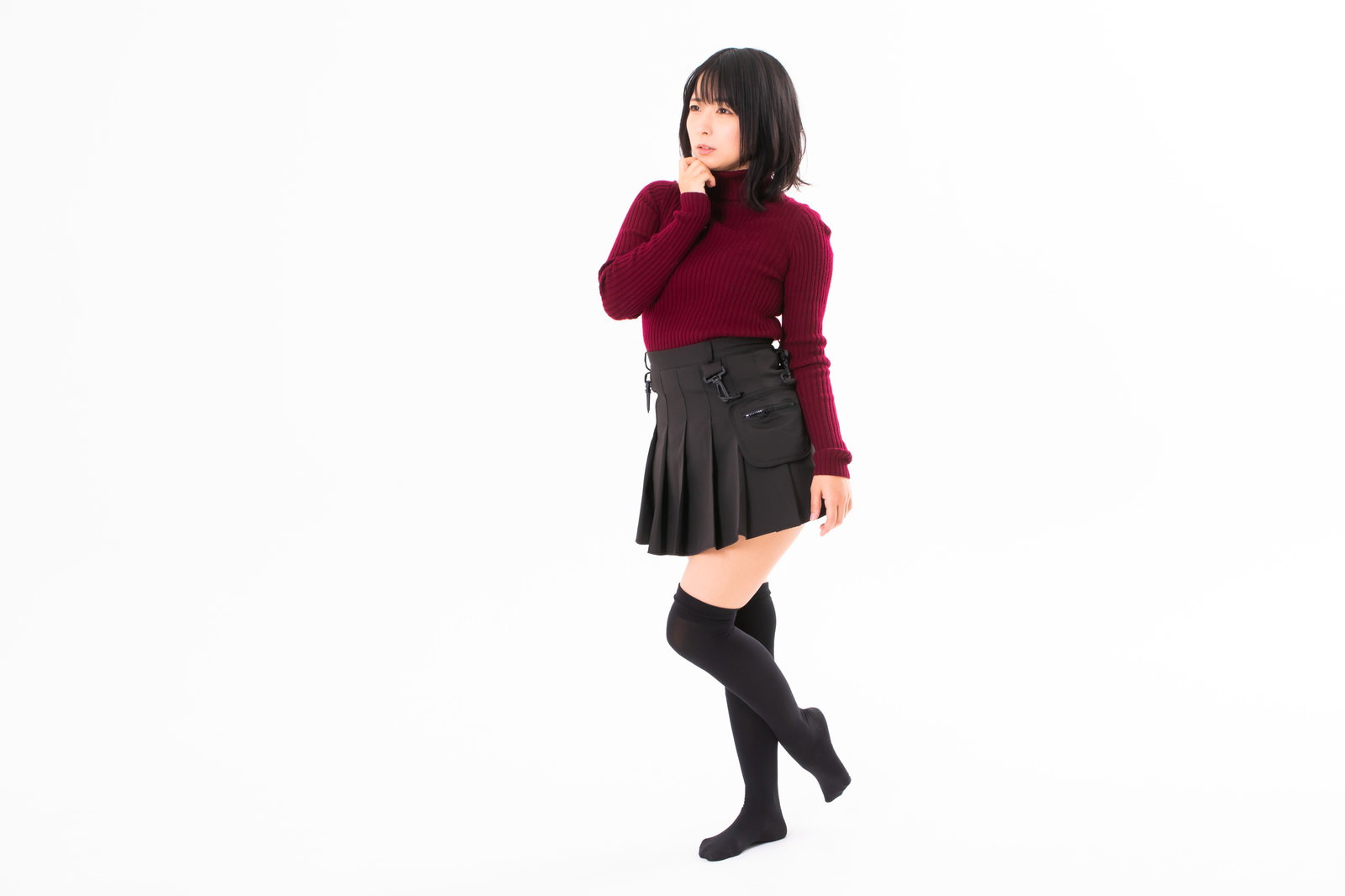 赤い服を着て腕組みをし、訝しげな表情で首をかしげる女性［モデル：にゃるる］