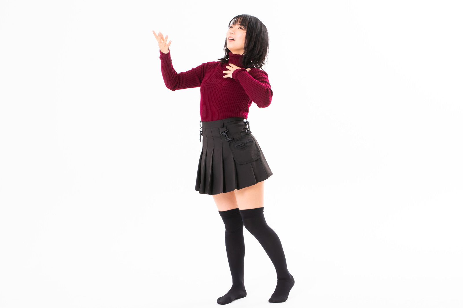 胸に手を当てて堂々としたポーズをとる赤いセーターの女性［モデル：にゃるる］