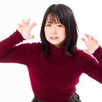 エンジ色ニットで両手でガオーポーズをする女性の写真