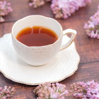 ティーカップのハーブティーとライラックの春の一杯の写真