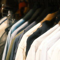 クローゼットのハンガーに整然とかけられた色とりどりの洋服の写真