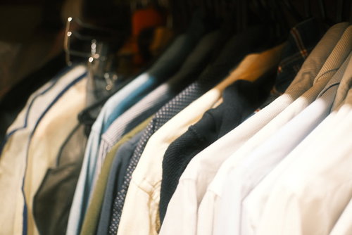 クローゼットのハンガーに整然とかけられた色とりどりの洋服
