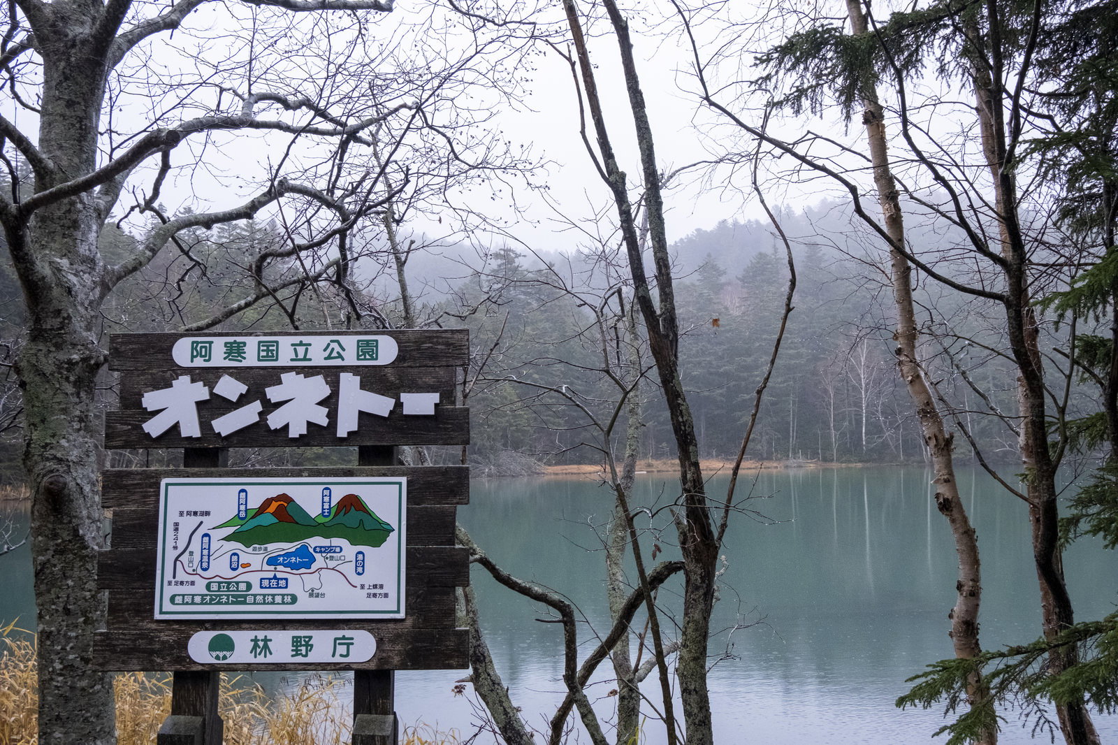 A wooden information signboard by the winter lake of Lake Onneto, Akan National Park, Hokkaido