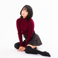 手を添えて床に横座りする女性のポートレートの写真