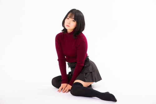 手を添えて床に横座りする女性のポートレート